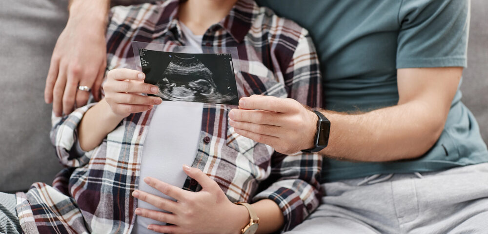 California couple expecting baby looking at sonogram